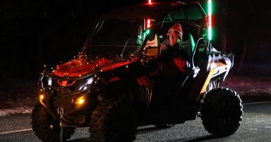 An ATV lit up with Christmas lights.
