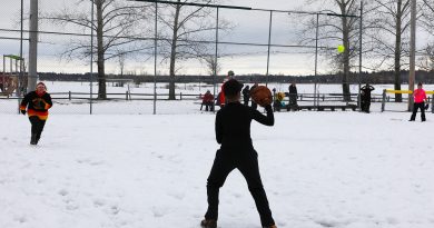 A photo of people playing ball in the snow.