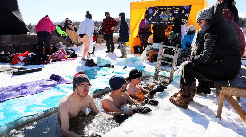 A photo of people dipping themsevles in freezing water.