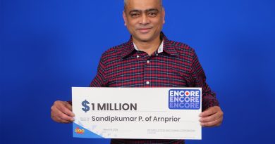 A man holds a real big cheque.
