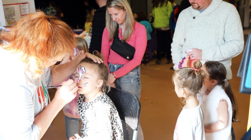 A photo of a child getting their face painted.