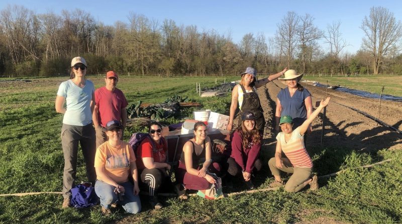 People pose for a photo in a field.