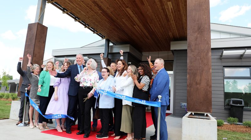 A photo of people cutting a ribbon.