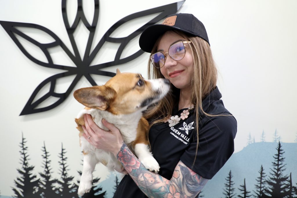 A woman and a dog pose for a photo.