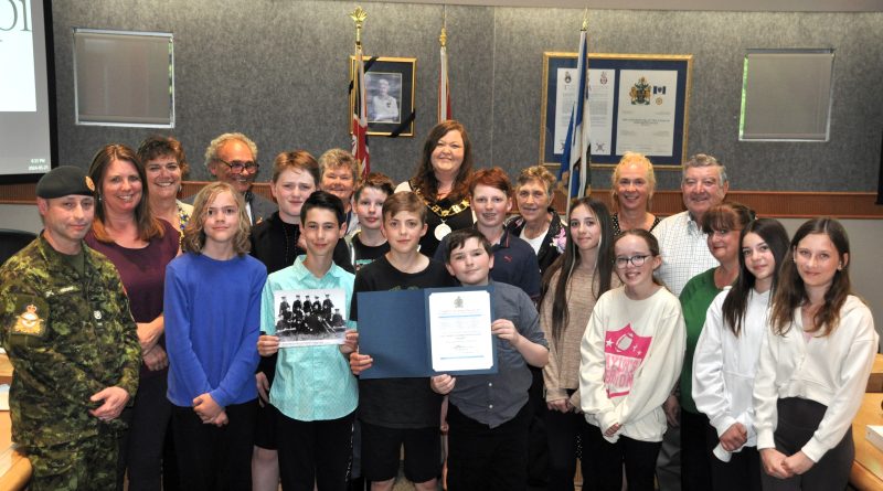 A group pose in the council chambers.