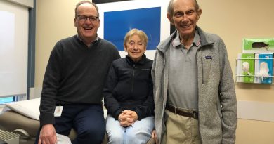 Three peopel pose in a doctor's office.