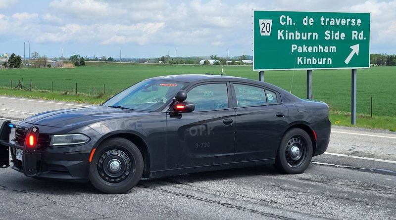 A photo of a police car parked on the highway.