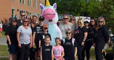 A group photo of a fundraising team with a unicorn.
