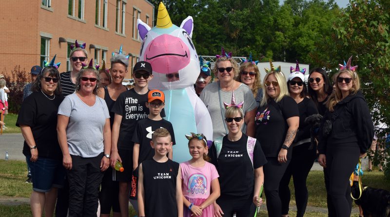 A group photo of a fundraising team with a unicorn.