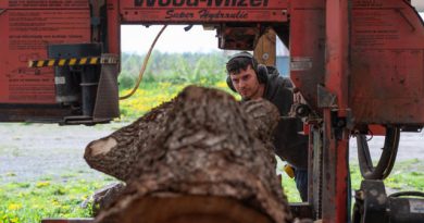 A photo of a person working a sawmill.