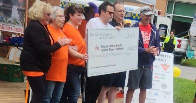 A group of people hold a big cheque.