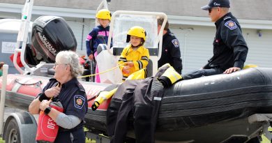 A boy performs a water rescue from a boat.