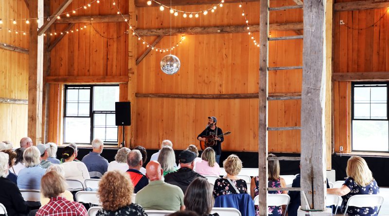 A person sings in a barn.