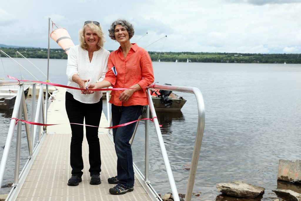 Two people cut a ribbon.