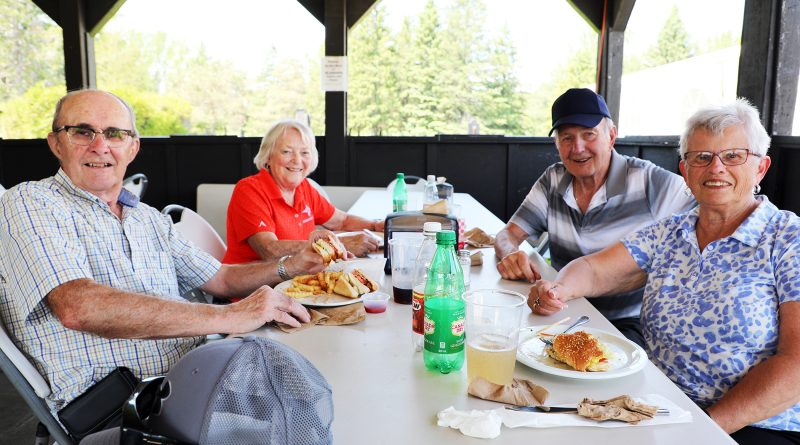 Four people eat lunch at a golf club.