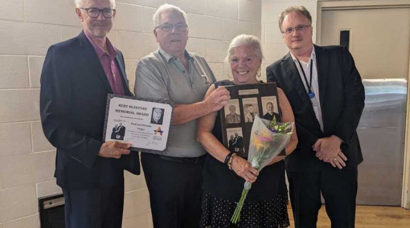 Four people pose with an award.