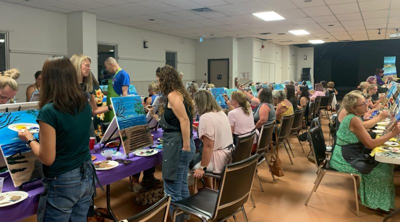 A photo of people painting in a room.