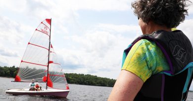 A person waves to sailors.