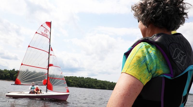 A person waves to sailors.