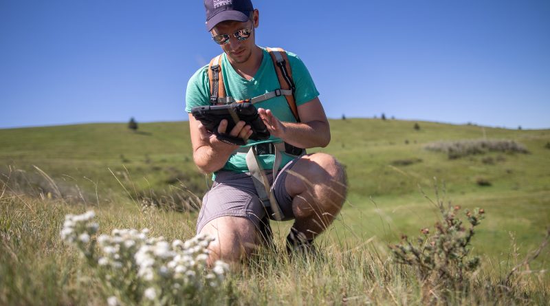 a man looks at a tablet in the wild.