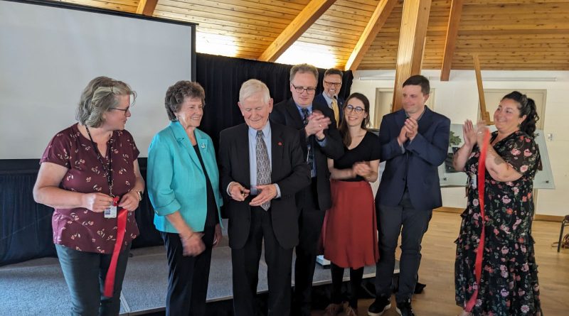 A photo of people cutting a ribbon.