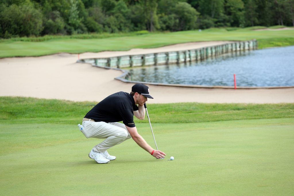 A golfer lines up a put.