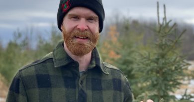 A man poses in a forest.