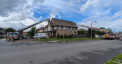 Two ladder trucks are used to fight a fire at a house.