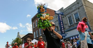 A women operates a pupet in a parade.