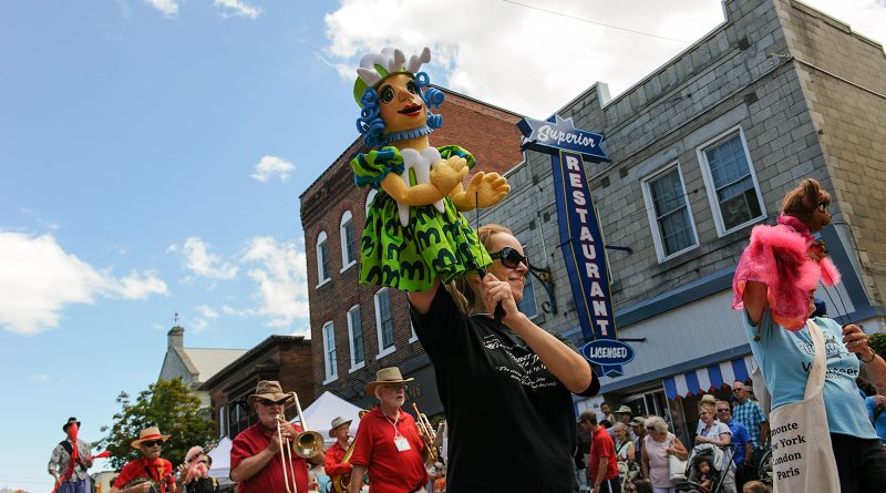 A women operates a pupet in a parade.