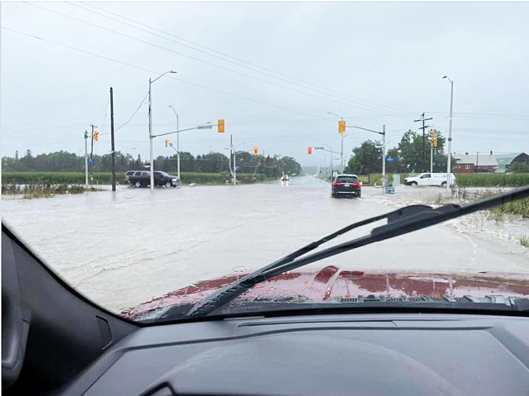 A photo of a flooded road taken from inside a car.