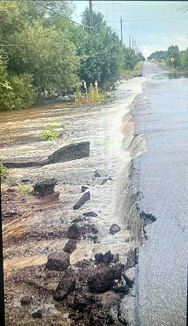 A road is washed out along the shoulder.