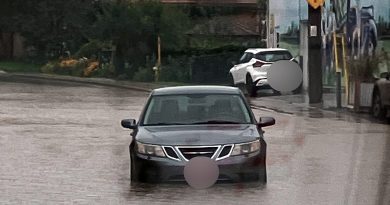 A car drives on a flooded road.