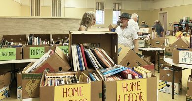 Two people talk at a book sale.