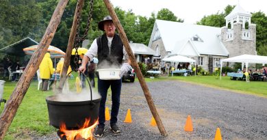 A man cooks corn from a pot.