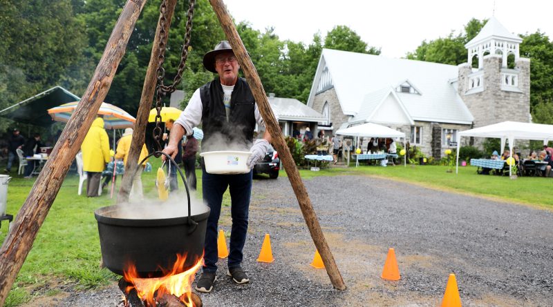 A man cooks corn from a pot.