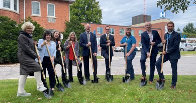 People with shovels pose for a photo.