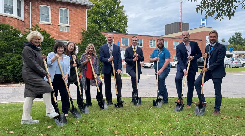 People with shovels pose for a photo.