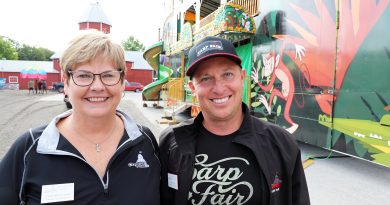 Two people pose for a photo on the fairgorounds.