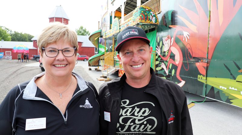 Two people pose for a photo on the fairgorounds.