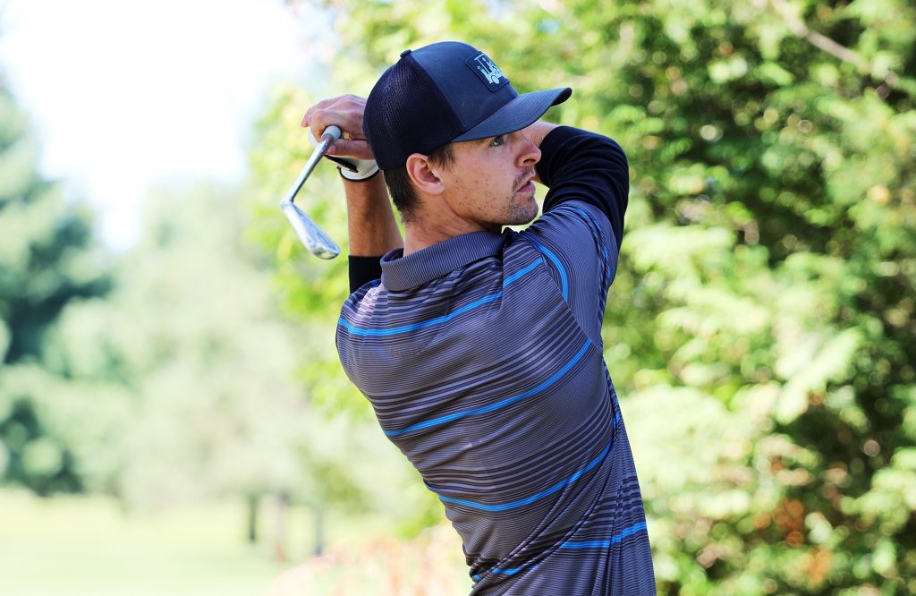 A golfer watches his shot.