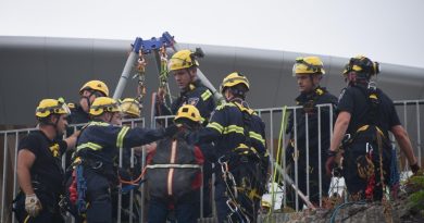 Rescue workers help a clofff climber.