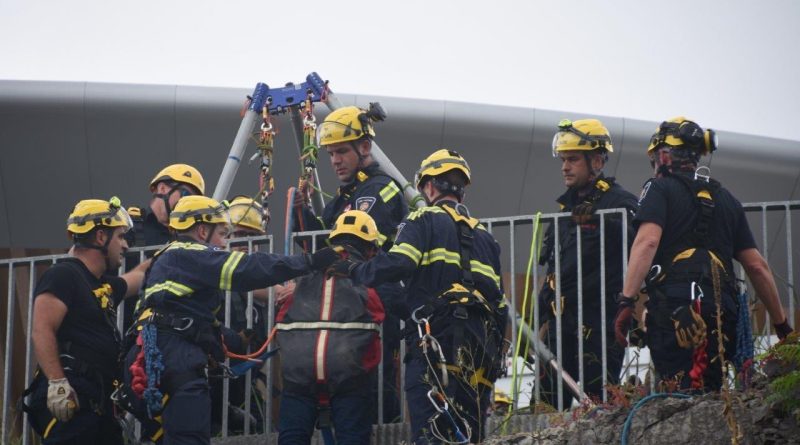 Rescue workers help a clofff climber.