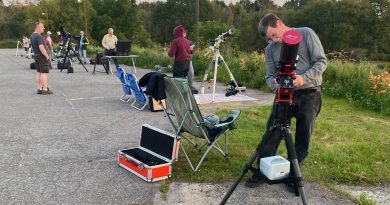 People set up telescopes in a parking lot.