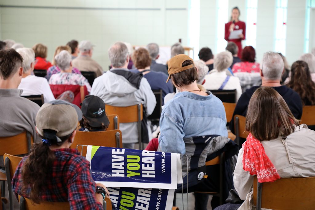 A group of people listen to a speaker.