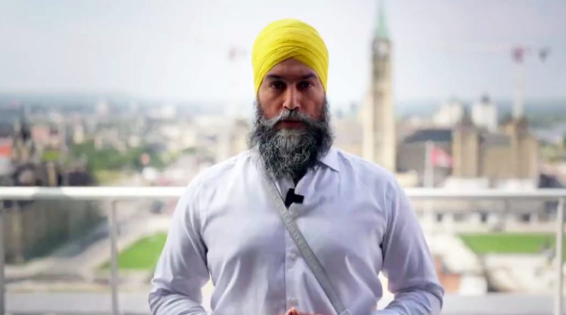 A man poses in front of the Parliament Building.