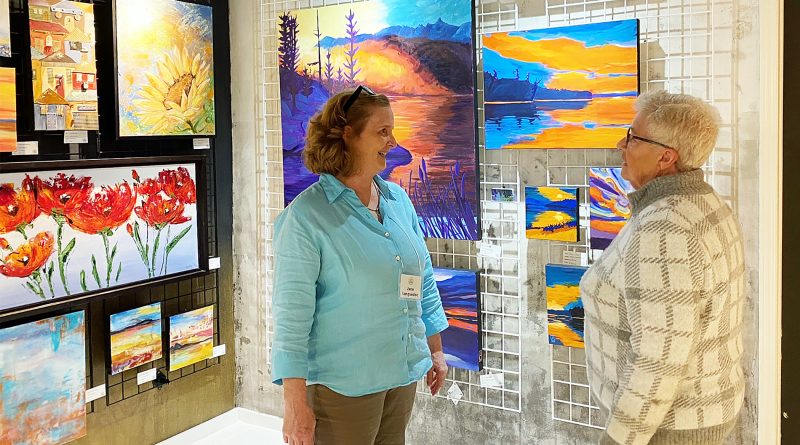 Two people talk in a gallery.