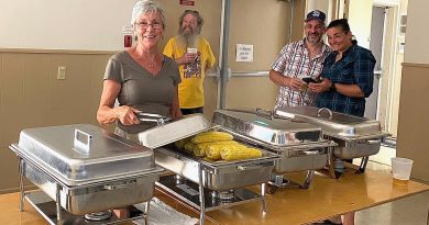 Volunteers serve corn.