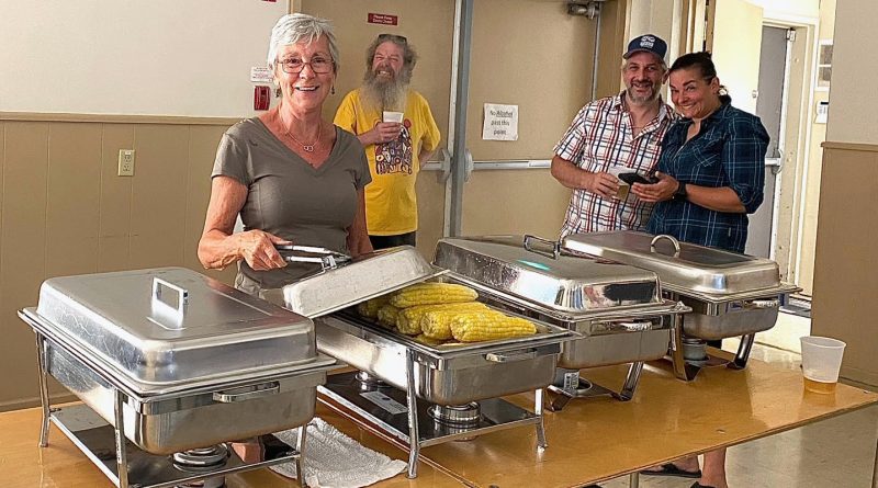 Volunteers serve corn.