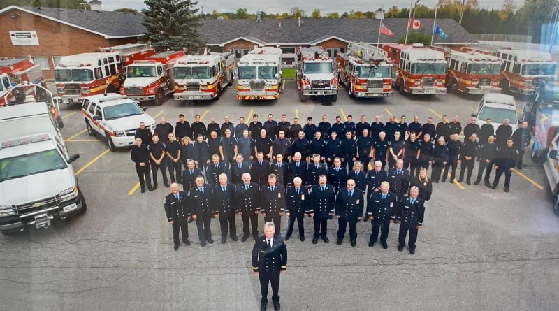 A photo of a whole bunch of firefighters and their equipment.